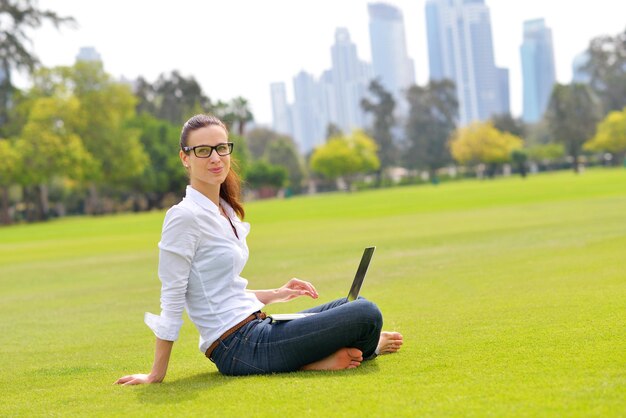 feliz joven estudiante mujer con laptop en el estudio del parque de la ciudad