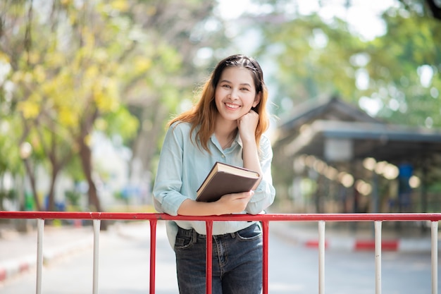 Feliz joven estudiante universitario asiático