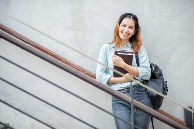 Feliz joven estudiante universitario asiático