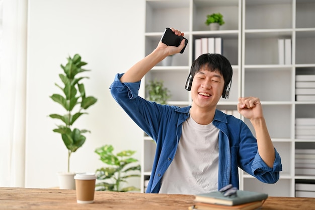 Feliz joven estudiante universitario diviértete escuchando música