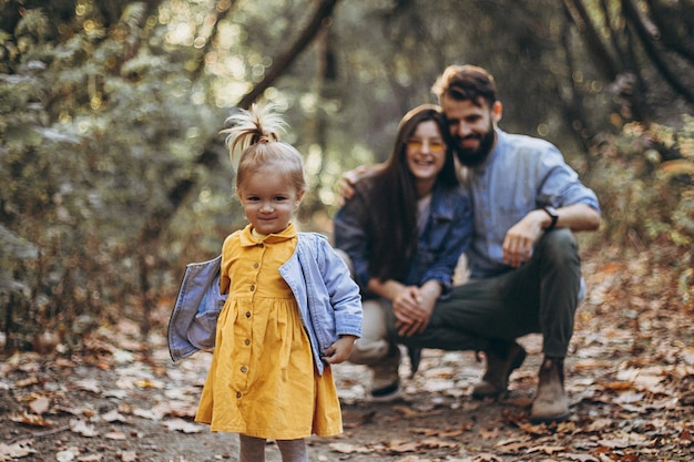 Feliz joven familia elegante padre hermosa mamá y dulce hijita pasan un día juntos niño corriendo en la naturaleza al atardecer efecto de ruido de enfoque selectivo