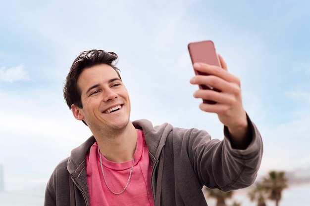 Feliz joven grabando una videollamada con teléfono