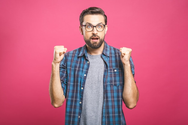 Feliz joven guapo gesticulando y manteniendo la boca abierta