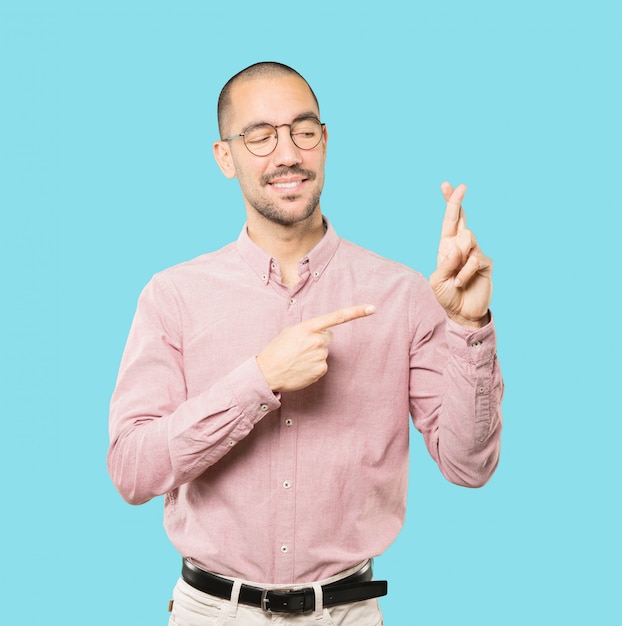 Feliz joven haciendo un gesto de dedos cruzados