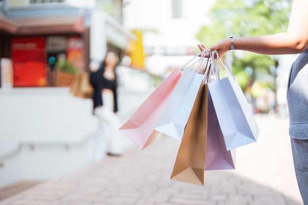 Feliz joven hermosa y elegante mujer con bolsa de compras mientras caminaba salió del centro comercial el viernes negro de vacaciones