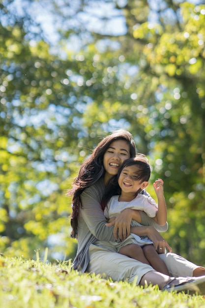 Feliz joven hija con mamá en el parque