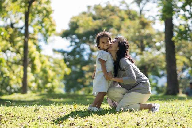 Feliz joven hija con mamá en el parque