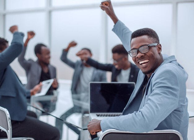 feliz, joven, hombre de negocios, sentado, en, oficina, escritorio