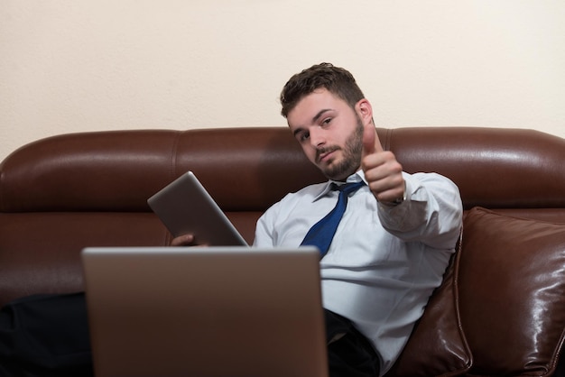 Feliz joven hombre de negocios trabaja en la oficina moderna en la computadora