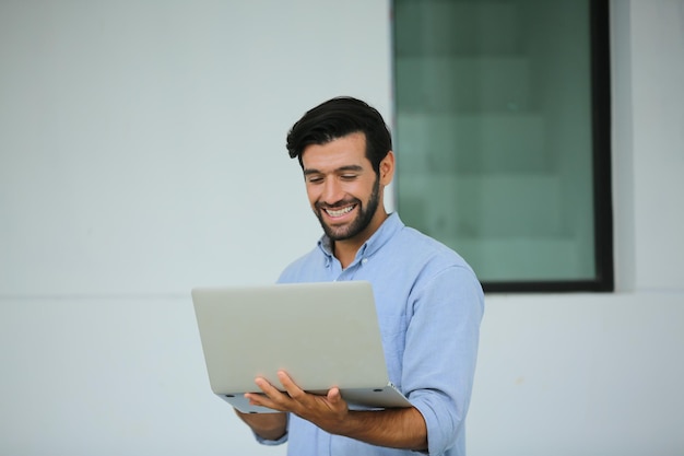 feliz, joven, hombre de negocios, utilizar, computador portatil