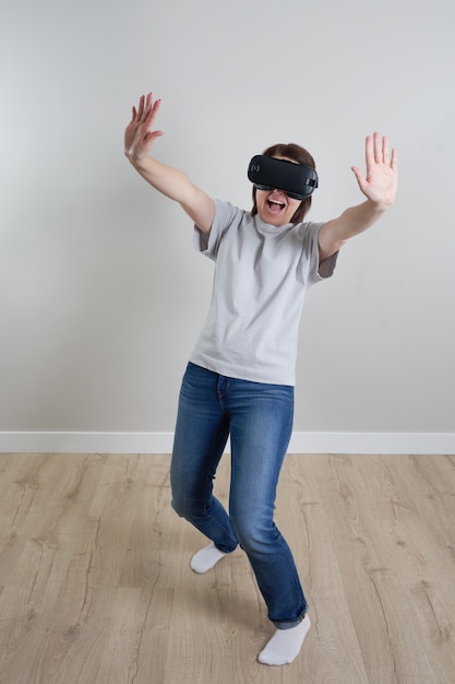 Foto feliz joven jugando con gafas de realidad virtual interior, concepto de realidad virtual con niña divirtiéndose con gafas de auriculares,