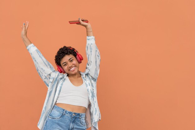 Feliz joven latina con smartphone y auriculares bailando en la calle Panamá Centroamérica