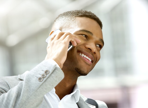 Feliz joven llamando por teléfono móvil