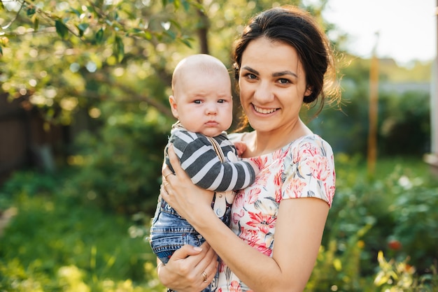 Feliz joven madre caucásica con un hijo recién nacido niño en manos sonriendo