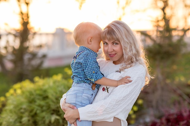 Feliz joven madre divirtiéndose con su hijo en un día soleado de verano Estilo de vida familiar