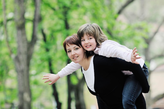 feliz joven madre e hija se divierten al aire libre