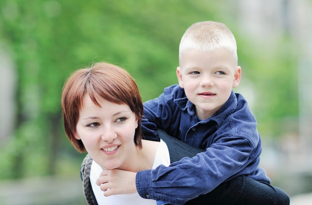 feliz joven madre e hijo se divierten al aire libre