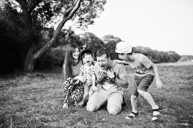 Feliz joven madre de familia padre dos hijos hijo en la naturaleza divirtiéndose