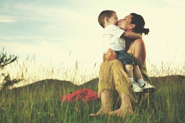 feliz joven madre jugar y al aire libre con hermoso niño