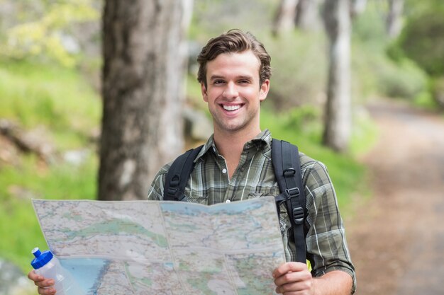 Feliz joven con mapa en sendero