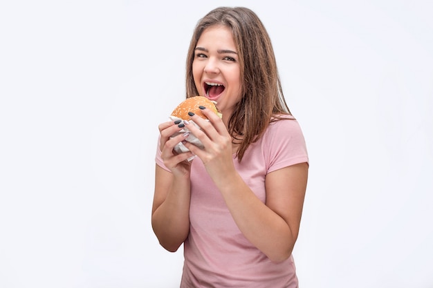 Foto feliz joven mira a la cámara con la boca abierta