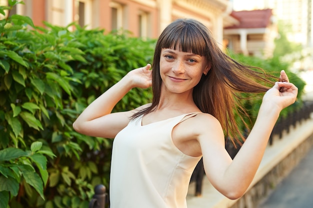 Feliz joven morena con pecas en el rostro en un día soleado