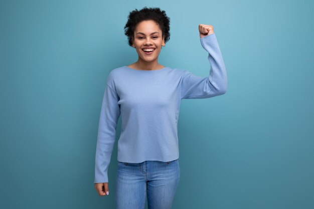 Feliz joven morena con rizos afro ganó y se regocija