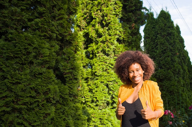 La feliz y joven mujer afroamericana en la calle divirtiéndose