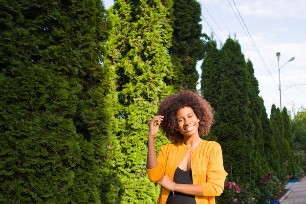 La feliz y joven mujer afroamericana en la calle divirtiéndose