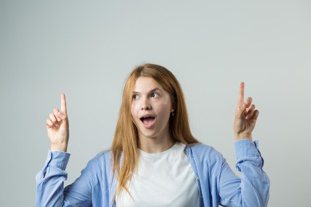 Feliz joven mujer caucásica señalando con el dedo