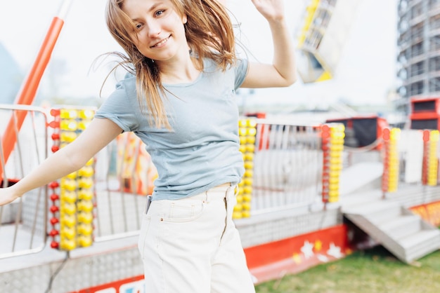 Feliz joven mujer Gen Z en un parque de diversiones saltando y sonriendo