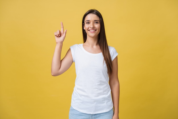 Feliz joven mujer de pie y apuntando el dedo