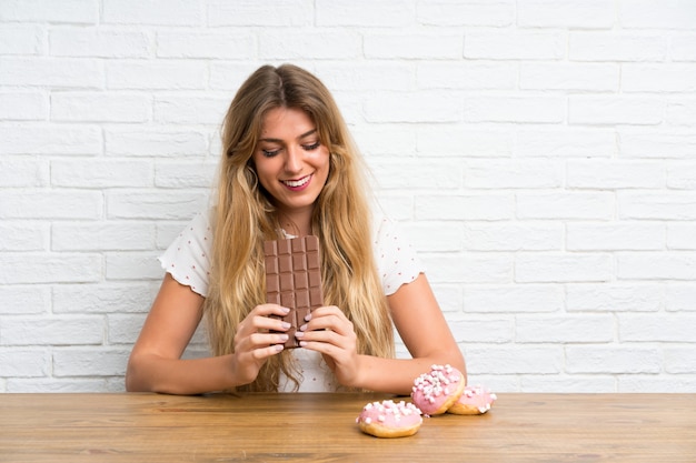 Feliz joven mujer rubia con chocolate