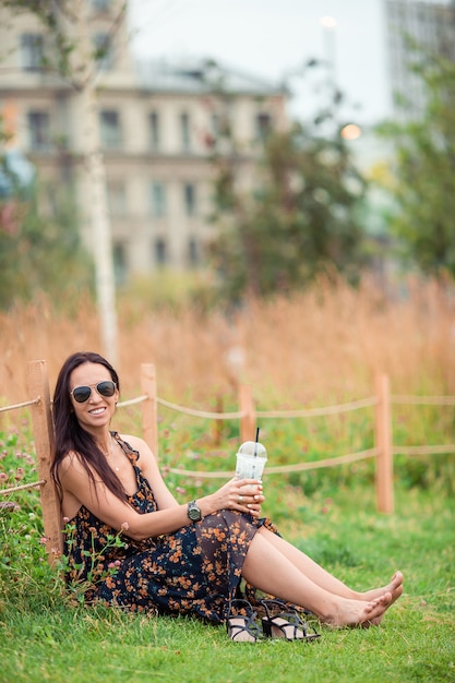 Feliz joven mujer urbana tomando café al aire libre