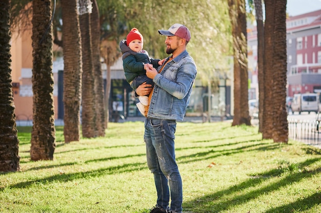 Feliz joven padre caminando con su pequeño hijo