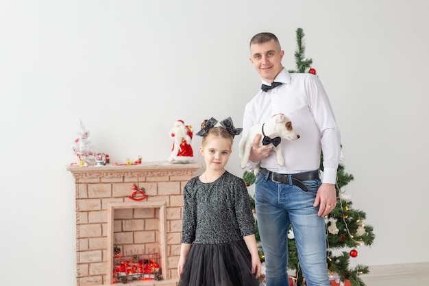 Feliz joven padre y su hija en casa con árbol de Navidad