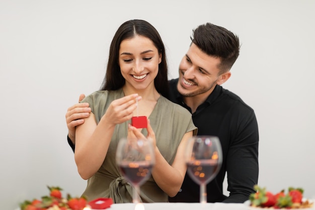 Feliz joven pareja amorosa celebrando el día de San Valentín intercambiando regalos