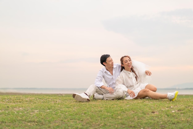 Feliz joven pareja asiática vestida de novia y novio lista para casarse y celebrar la boda