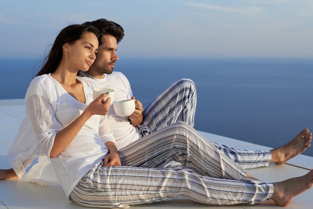 feliz joven pareja romántica diviértete relájate sonríe en casa moderna balcón terraza al aire libre