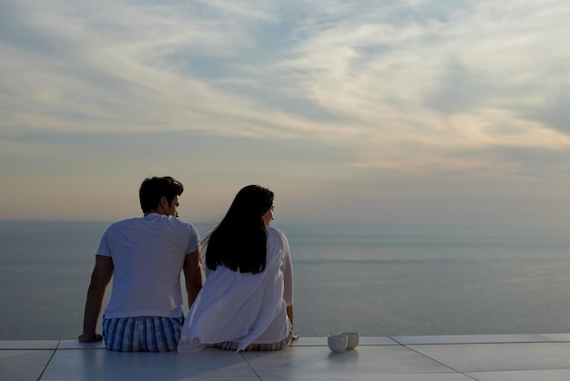 feliz joven pareja romántica diviértete relájate sonríe en casa moderna balcón terraza al aire libre