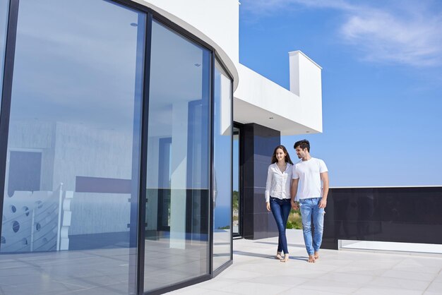 feliz joven pareja romántica diviértete relájate sonríe en casa moderna terraza al aire libre balcón terraza