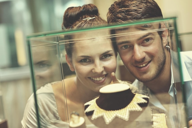 feliz joven pareja romántica enamorada comprar anillo de joyería en una tienda de lujo