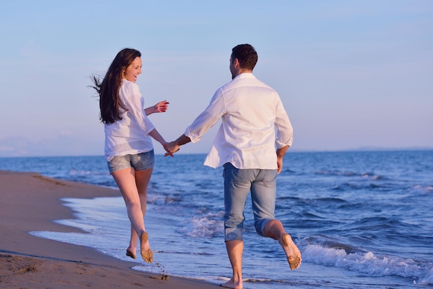 feliz joven pareja romántica enamorada diviértete en la hermosa playa en el hermoso día de verano