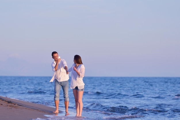 feliz joven pareja romántica enamorada diviértete en la hermosa playa en el hermoso día de verano