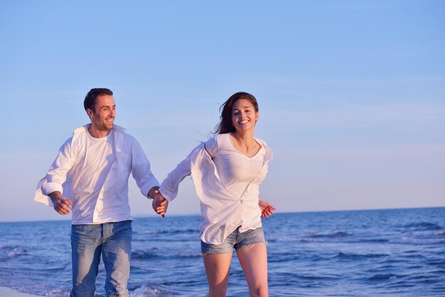 feliz joven pareja romántica enamorada diviértete en la hermosa playa en el hermoso día de verano