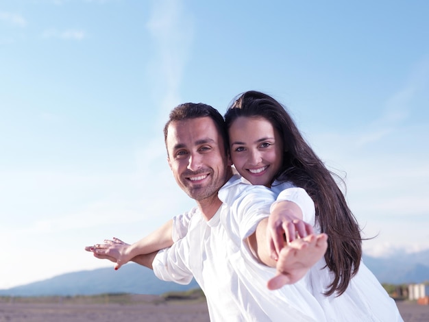 feliz joven pareja romántica enamorada diviértete en la hermosa playa en el hermoso día de verano