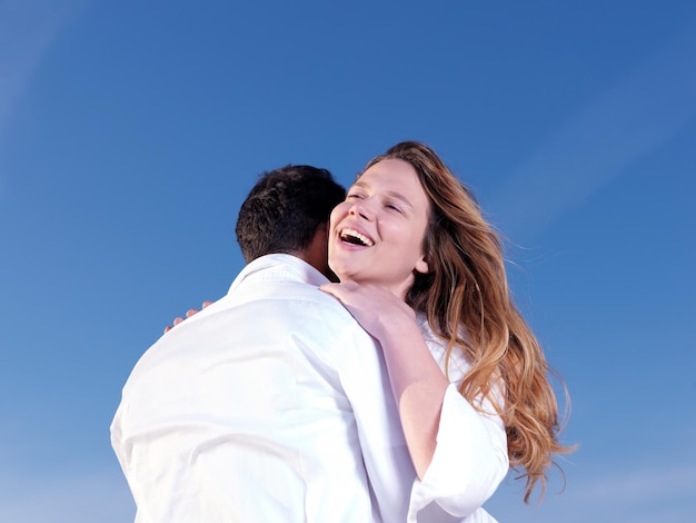 feliz joven pareja romántica enamorada diviértete en la hermosa playa en el hermoso día de verano