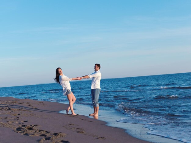 feliz joven pareja romántica enamorada diviértete en la hermosa playa en el hermoso día de verano