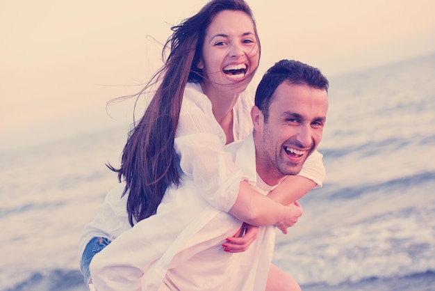 feliz joven pareja romántica enamorada diviértete en la hermosa playa en el hermoso día de verano