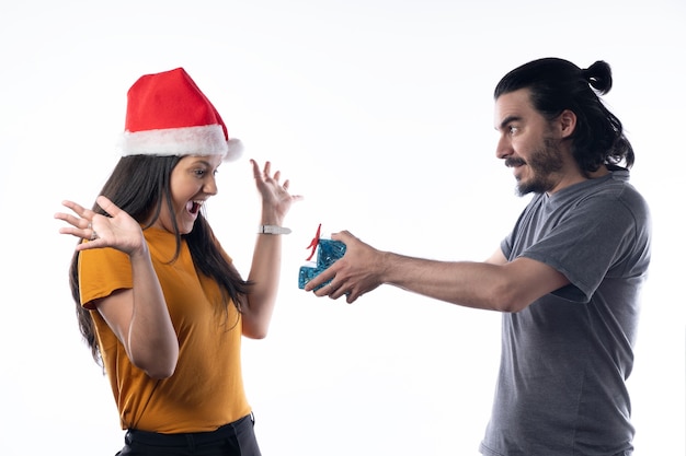 Feliz joven recibiendo regalos de Navidad de su marido sobre fondo blanco.